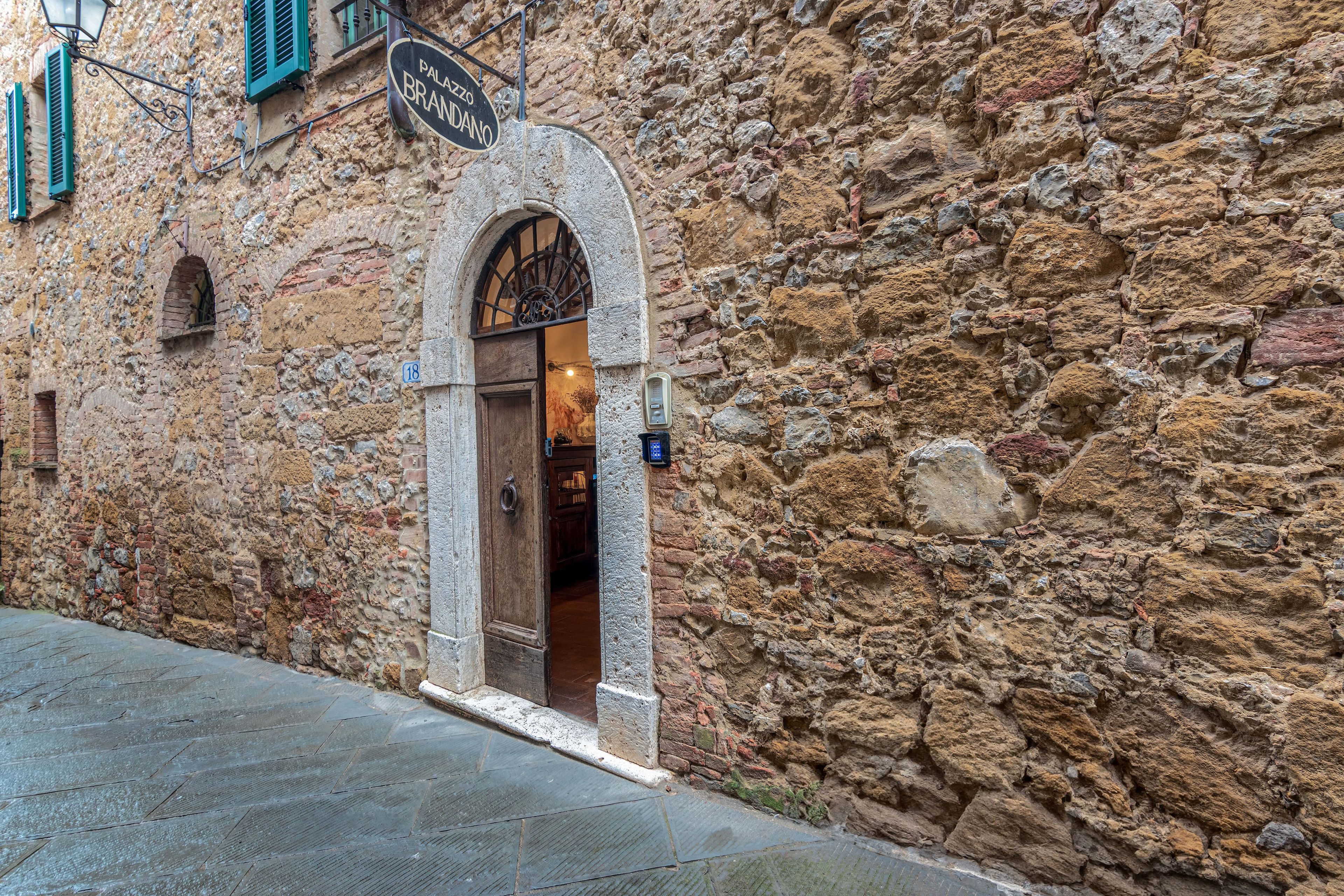 A stone building with a sign reading "Palazzo Brandano".