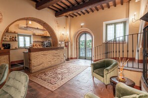 A spacious living area with a kitchen, a staircase, and a view of the outdoors. - Palazzo Brandano (Trequanda)