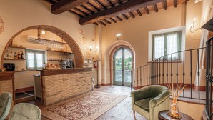 A spacious living area with a kitchen, a staircase, and a view of the outdoors. - Palazzo Brandano (Trequanda)
