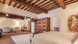 A bedroom with a large bed, wooden wardrobe, and a painting on the wall. - Palazzo Brandano (Trequanda)
