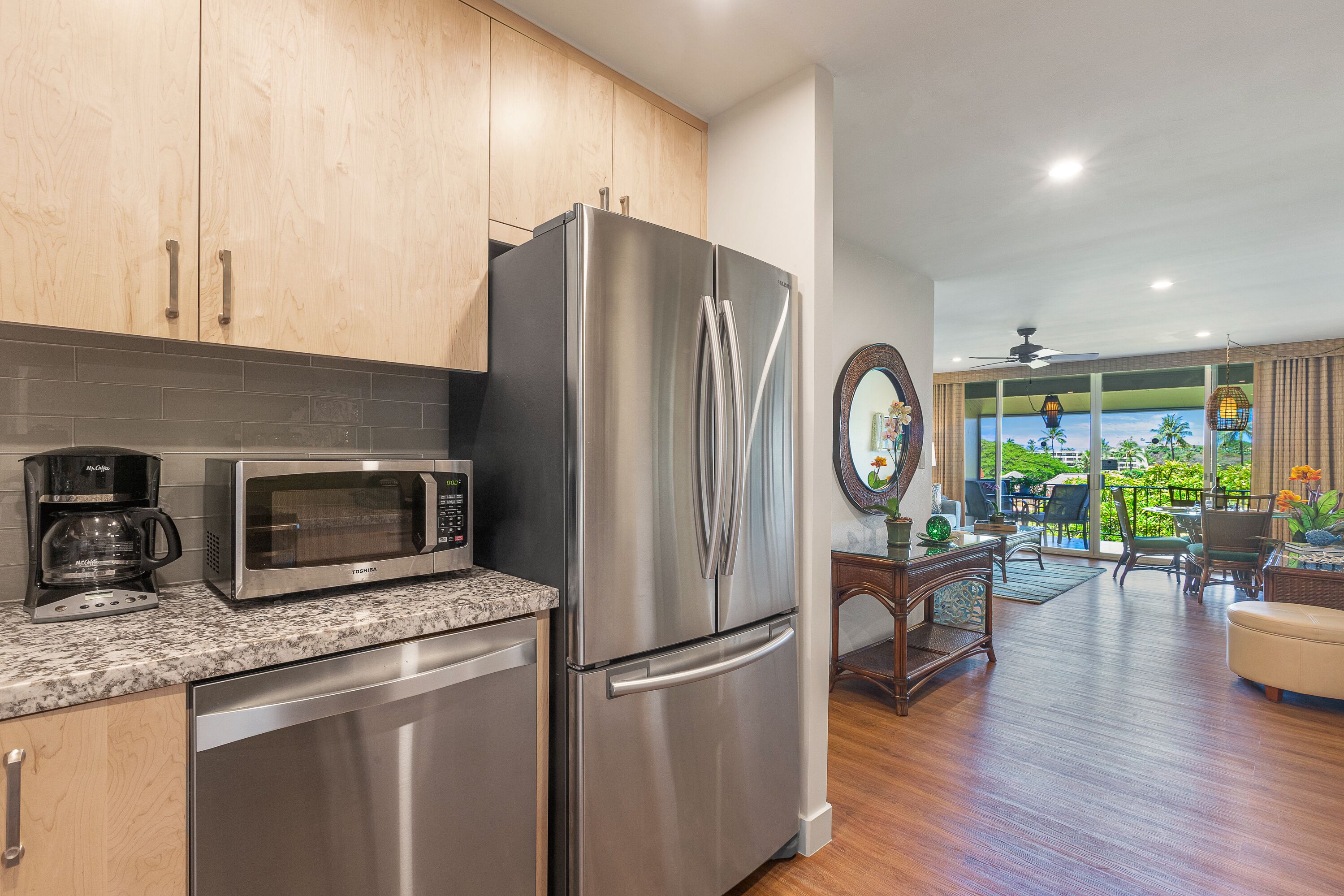 A kitchen with stainless steel appliances, a microwave, and a coffee maker.