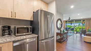 A kitchen with stainless steel appliances, a microwave, and a coffee maker.