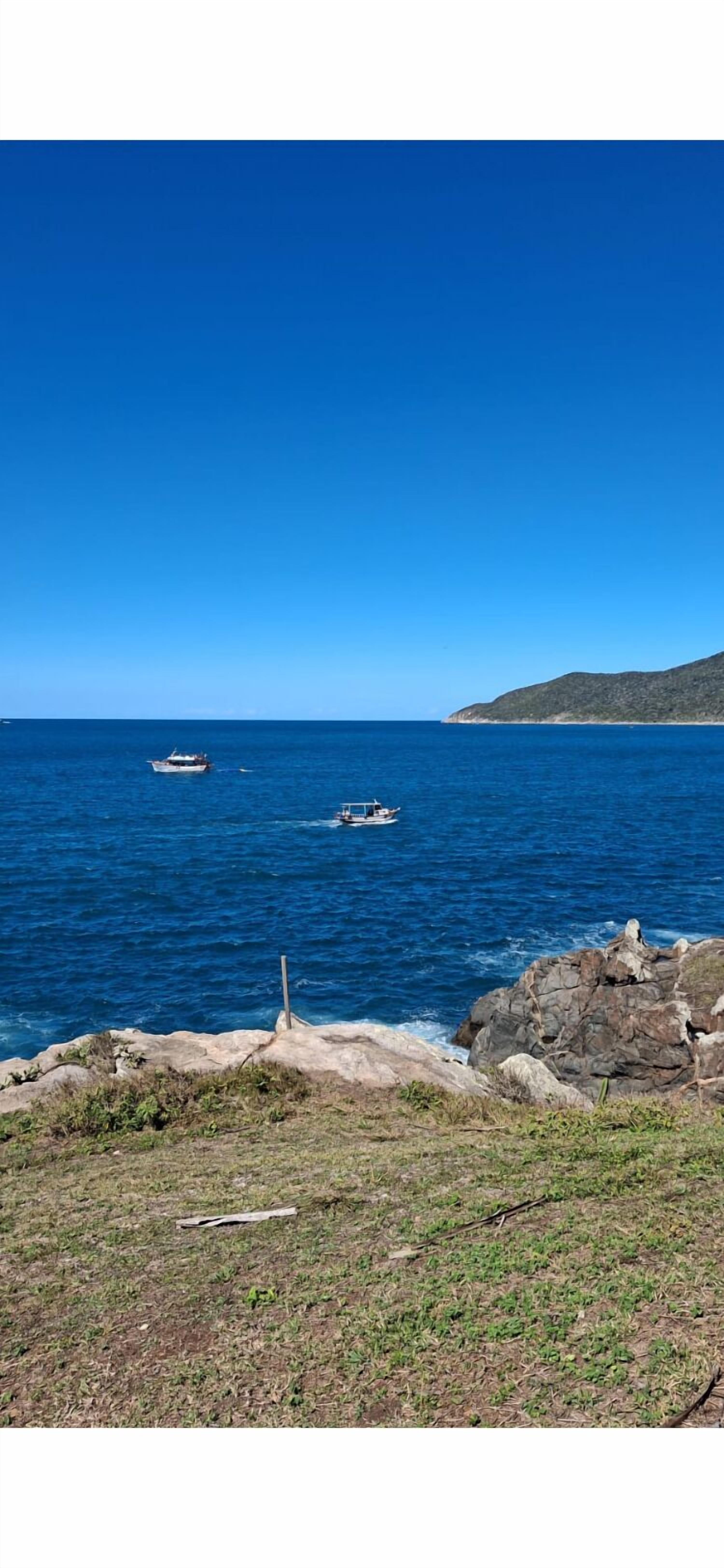 Eine Küstenlandschaft mit felsigem Gelände und blauem Meer.