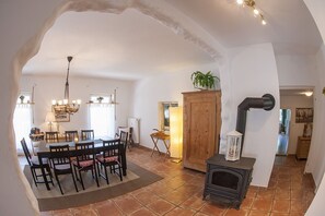 Un coin repas avec une table et des chaises, un buffet en bois, une cuisinière et une plante.