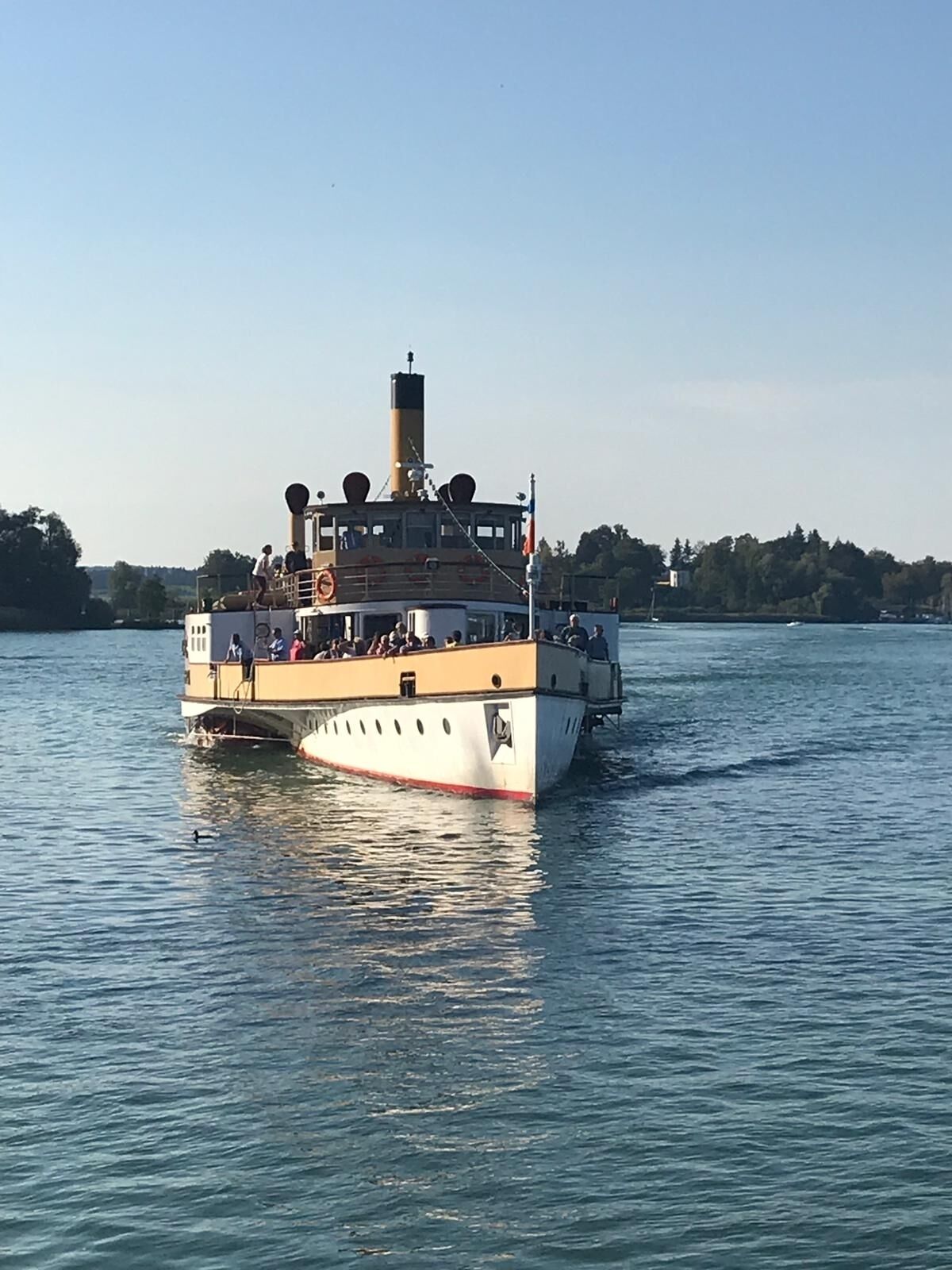 Un ferry con pasajeros, una cabina y un puente.