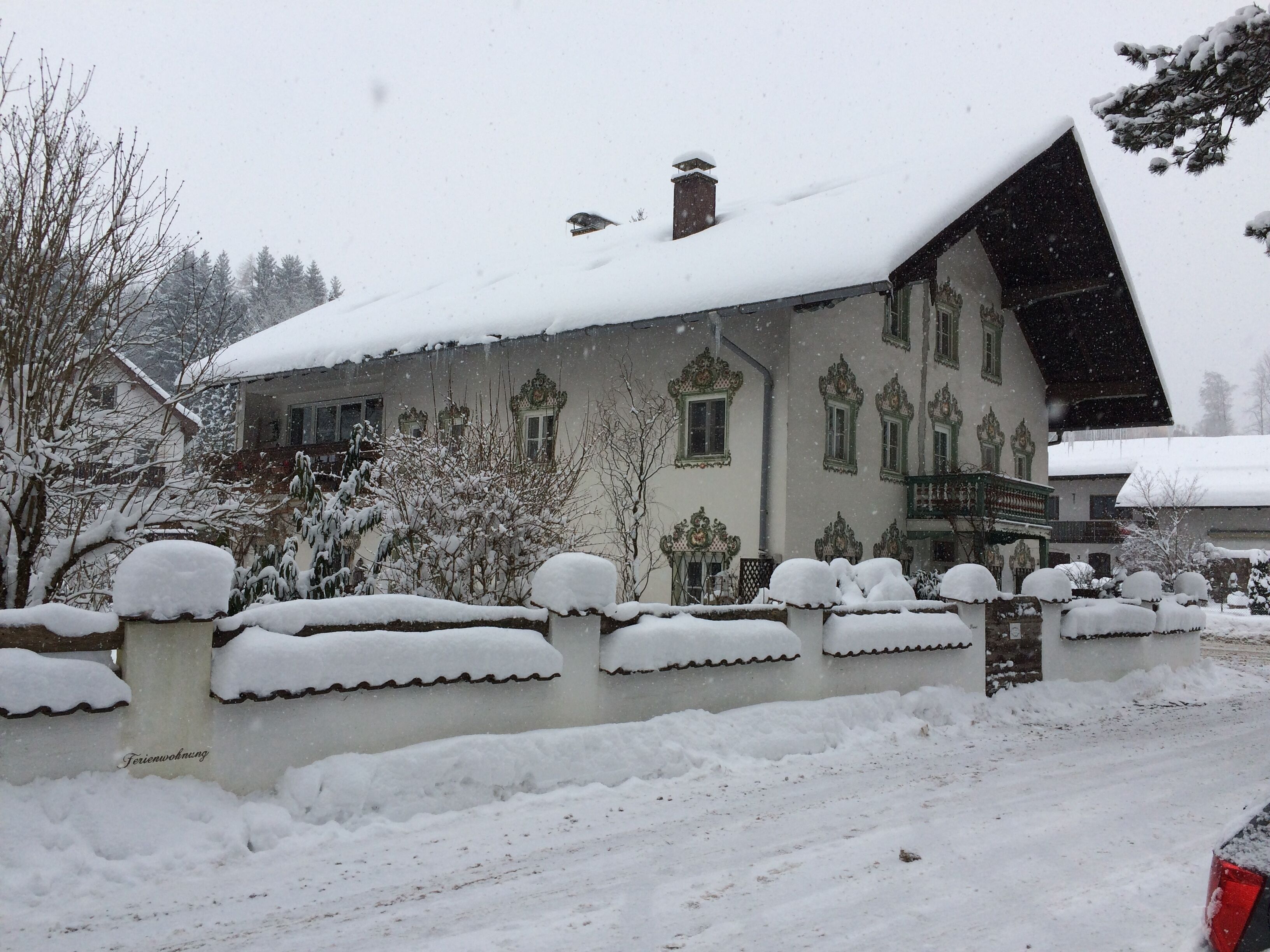 A snow-covered building with ornate architectural details and a steeply pitched roof.