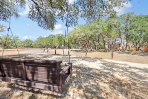 A park with a wooden bench, trees, and a clear sky. - Coyote Cabin- Wimberley, Stargazing, Couples (Wimberley)