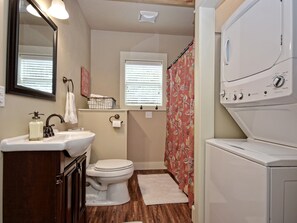 A bathroom with a sink, toilet, and a washing machine.
