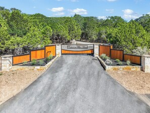 A gated entrance to a property with a sign reading "Cabins at Pine Acres." - Morning Dove I Romantic, Minutes from The Square! (Wimberley)