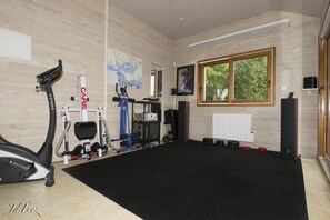 A gym with exercise equipment, a large window, and a map on the wall.