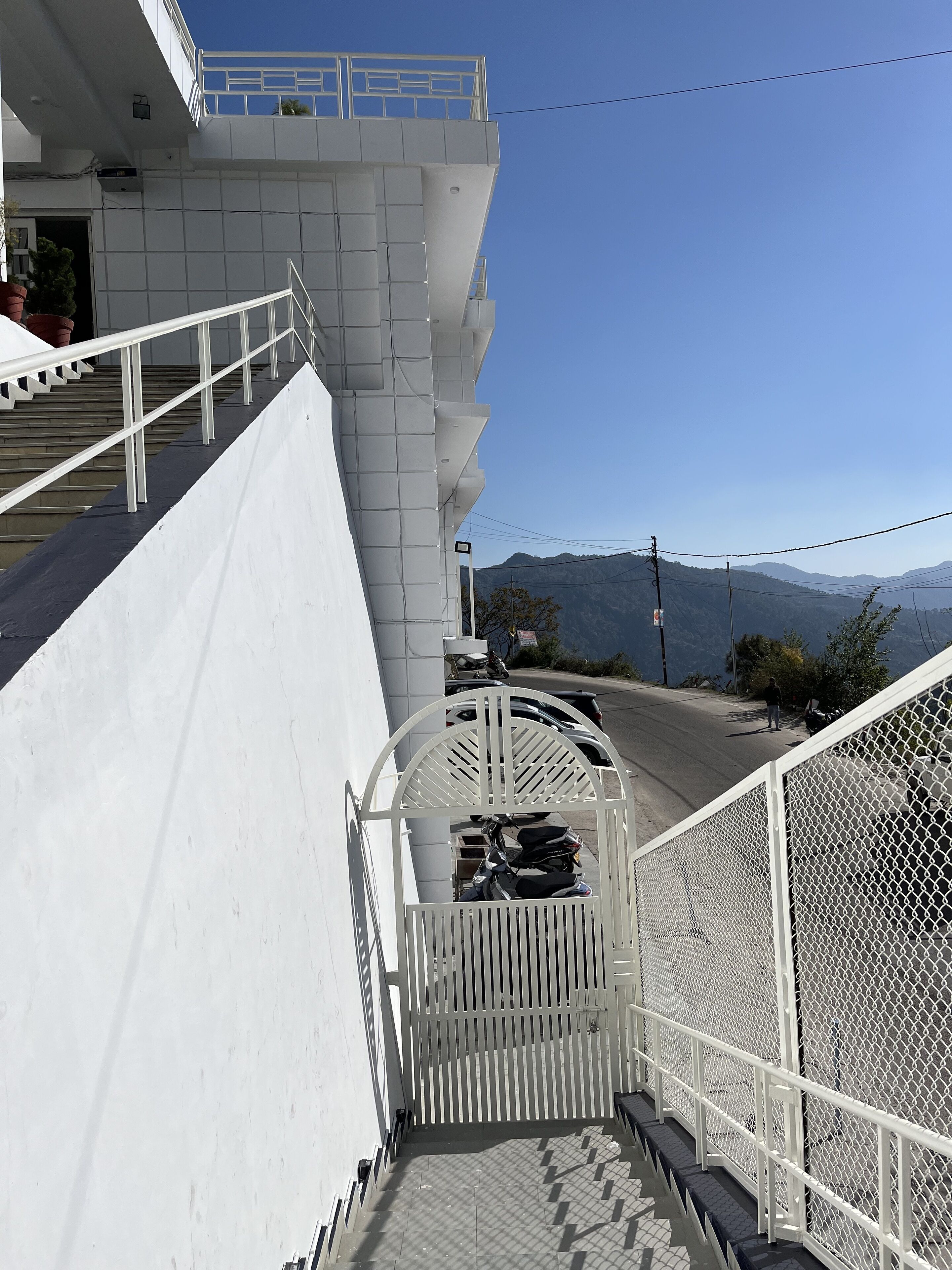 A staircase leading to a balcony with a view of mountains.