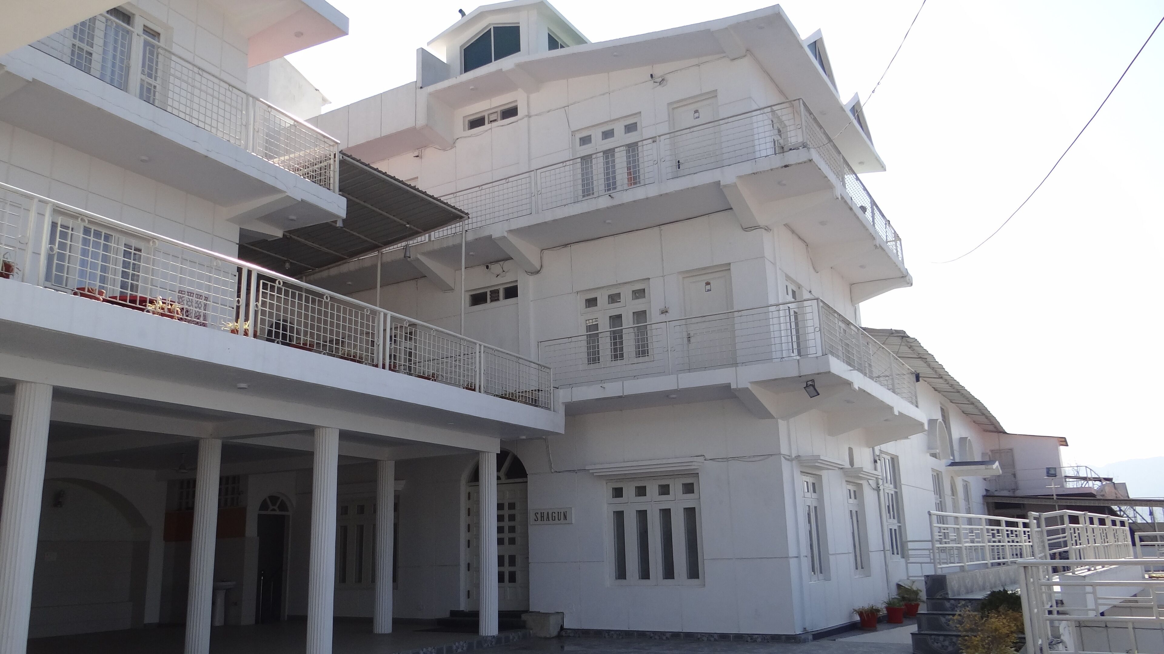 A multi-story building with balconies and a covered entrance.