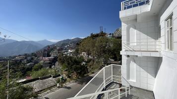 Zona residencial con un edificio blanco que tiene un balcón y una escalera.