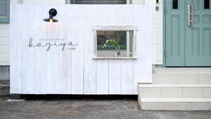 A white wooden structure with a small window and a light fixture, labeled "cafe & GuestHouse kaziyama 1699". - Cafe&Guest House Kaziya (Ichinoseki)