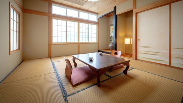 A traditional Japanese room with tatami flooring, a low wooden table, and sliding doors. - Cafe&Guest House Kaziya (Ichinoseki)
