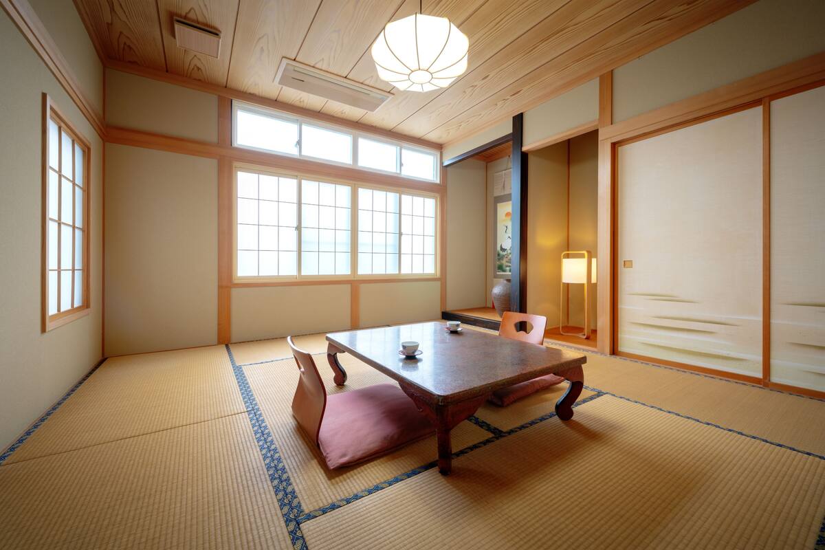 A traditional Japanese room with tatami flooring, a low wooden table, and sliding doors.