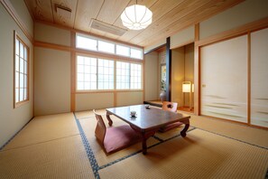 A traditional Japanese room with tatami flooring, a low wooden table, and sliding doors. - Cafe&Guest House Kaziya (Ichinoseki)