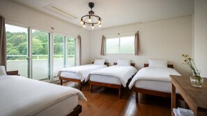 A hotel room with four beds, a wooden floor, a chandelier, and large windows with curtains. - Cafe&Guest House Kaziya (Ichinoseki)