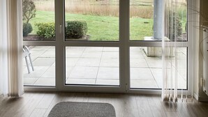 A room with a large sliding glass door leading to an outdoor patio area.