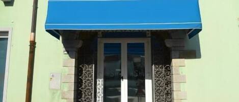 A hotel with a prominent sign reading "HOTEL SOLKI" and a blue awning over the entrance.