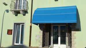 Un hotel con un toldo azul, un balcón con barandilla de metal y un letrero que dice "HOTEL SOLKI".