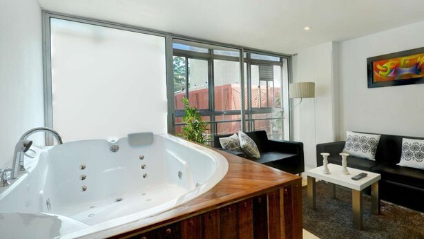 A modern bathroom with a freestanding bathtub and a large window. - Two Bedroom Middle of Park lleras AC, Hot tub Bars downstairs (Medellin)