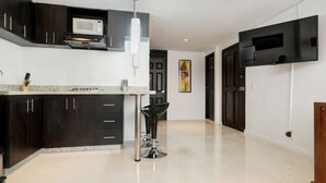 A modern kitchen with dark cabinetry, a built-in microwave, and a stainless steel sink. - Two Bedroom Middle of Park lleras AC, Hot tub Bars downstairs (Medellin)