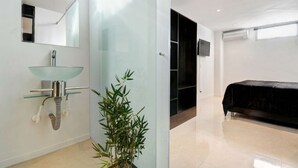 A modern bathroom with a glass sink, a mirror, and a bamboo plant. - Two Bedroom Middle of Park lleras AC, Hot tub Bars downstairs (Medellin)