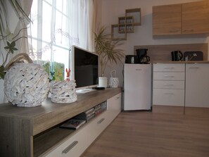 A modern kitchen with a wooden countertop, a white refrigerator, and a coffee maker. - Bungalow Vincent, with terrace, barbecue & WLAN - Bungalow with garden, terrace and (Zempin)