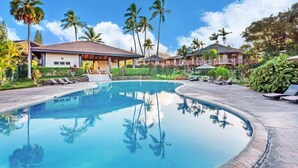 A swimming pool with lounge chairs, palm trees, and resort buildings. - North Shore Kauai- AC, pool, lanai; near beaches, golf, walking path to shops (Princeville)