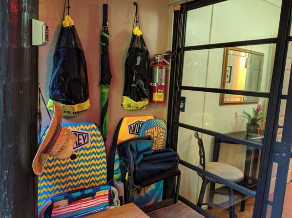Habitación con una silla de ruedas, un extintor y varias bolsas colgadas en la pared.