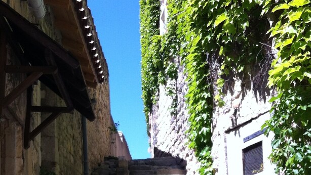 A narrow stone staircase leading up to a building with a window. - Character house at the foot of the castle. Shaded terrace (Boulbon)