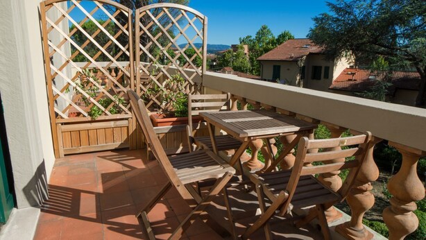 A wooden outdoor seating area with a view of the surrounding neighborhood. - B&B Dimora Salviati -  Suite (Firenze)