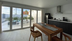Una cocina moderna con comedor, grandes puertas correderas de vidrio y vistas al exterior.