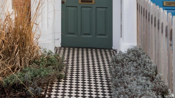 A traditional house with a green door, white arches, and a checkered pathway leading to the entrance. - Stylish Double en suite bedroom in Crouch End (London)