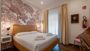 Ein Schlafzimmer mit einem hölzernen Bett, einem Nachttisch, einer Wandleuchte, einem Feuerlöscher und einem Sessel.