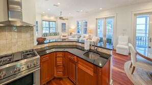 A modern kitchen with a central island, stainless steel appliances, and wooden cabinets. - Luxury Old Seagrove, BeachComer, Walk to Beach and Seaside, 3 King BRs, Private Heated Pool (Seagrove Beach)