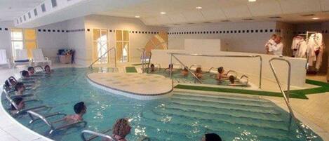 Ein Hallenbad mit mehreren Bahnen und einem zentralen Bereich für Wassersport.