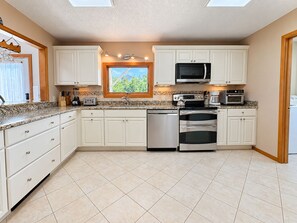 A kitchen with white cabinets, a microwave, an oven, and a dishwasher.