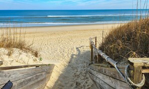 A wooden pathway leading to a sandy beach with a wooden fence and rope barrier. - Luzon - 5 BR, 4.5 BA, Oceanside home in Duck w/Private Pool (Duck)