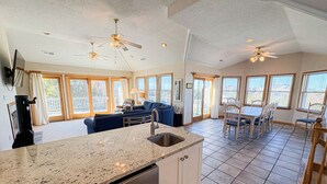 A spacious kitchen with granite countertops, a dishwasher, and a dining area with a table and chairs. - Luzon - 5 BR, 4.5 BA, Oceanside home in Duck w/Private Pool (Duck)