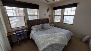 A bedroom with a bed, a desk, and two windows with blinds. - Granby Ranch Ski Condo with King Bed & Bunkbed! (Granby)