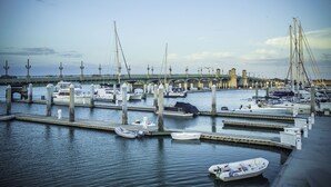 A marina with boats docked, a bridge in the background, and a calm water surface. - Renovated, Cozy 2Bd 2Ba, Steps from Private Beach & Pool! (St. Augustine)