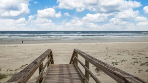 A wooden boardwalk leading to a beach with a clear sky and ocean in the background. - Renovated, Cozy 2Bd 2Ba, Steps from Private Beach & Pool! (St. Augustine)