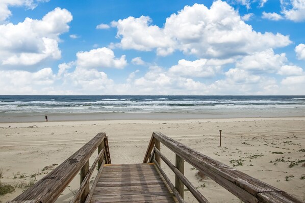 A wooden boardwalk leading to a beach with a clear sky and ocean in the background. - Renovated, Cozy 2Bd 2Ba, Steps from Private Beach & Pool! (St. Augustine)