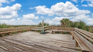 A wooden deck with benches and a rope barrier, overlooking a coastal landscape. - Renovated, Cozy 2Bd 2Ba, Steps from Private Beach & Pool! (St. Augustine)