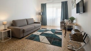 Un salon moderne comprenant un canapé, une table basse, un téléviseur et un coin repas.