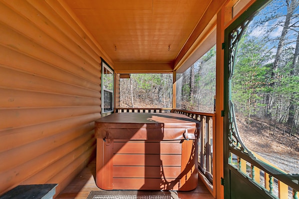 Uma cabana de madeira com uma banheira de hidromassagem grande, retangular e marrom no centro.