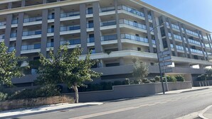 A multi-story building with a modern architectural design, featuring balconies and large windows. - Standing apartment seen on sea (Propriano)