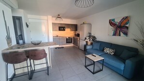 A modern apartment with a kitchen, dining area, and living room. - Standing apartment seen on sea (Propriano)